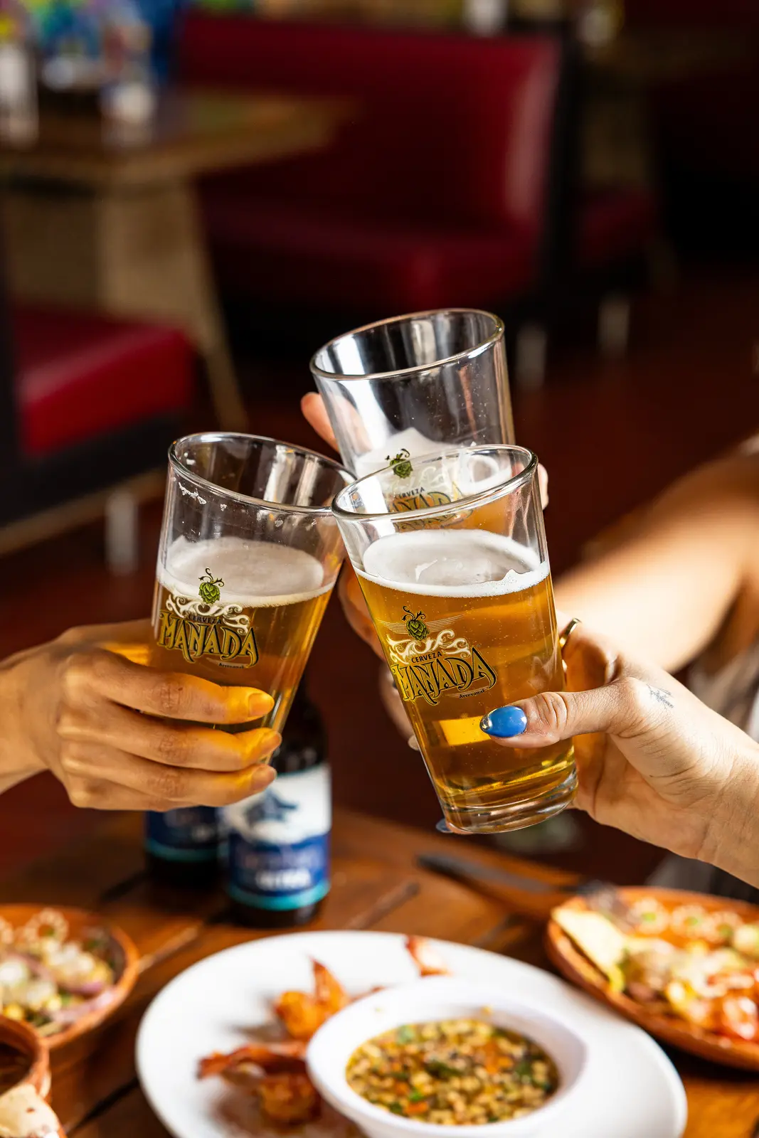 Amigos brindando y compartiendo cerveza Manada